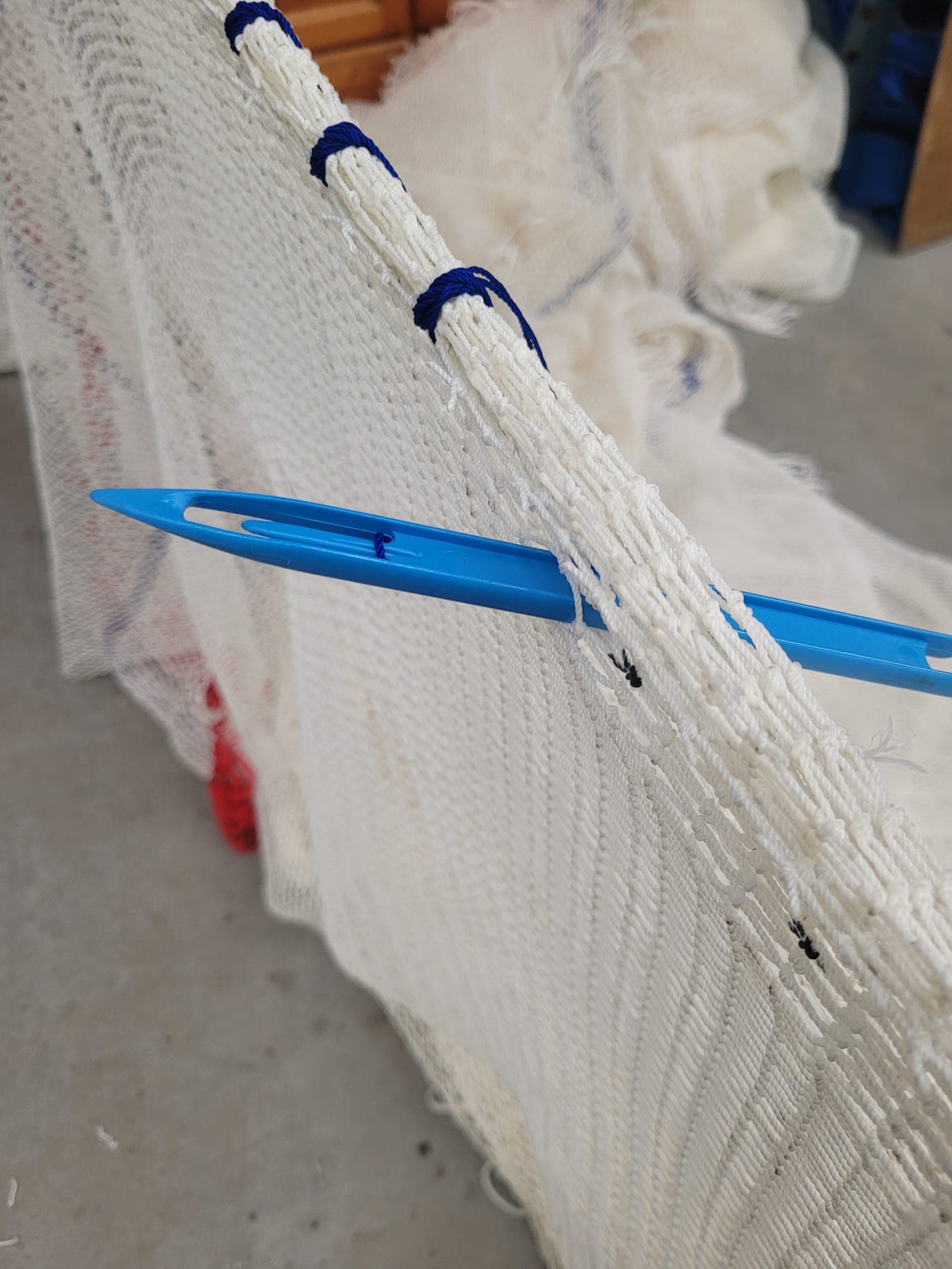 Boetnaald door een garnalennet — vakkundig handwerk